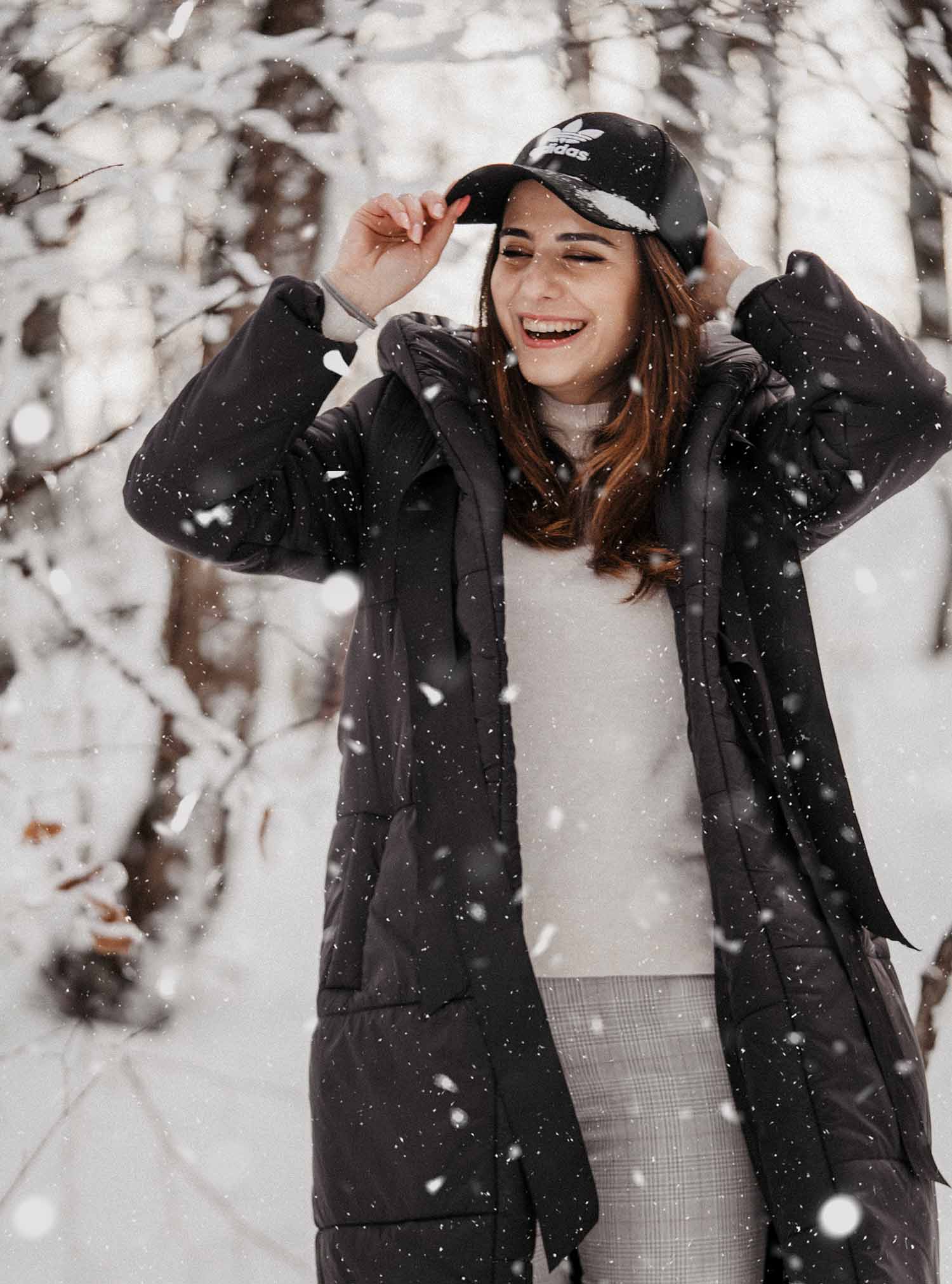 a person wearing a hat and coat in the snow